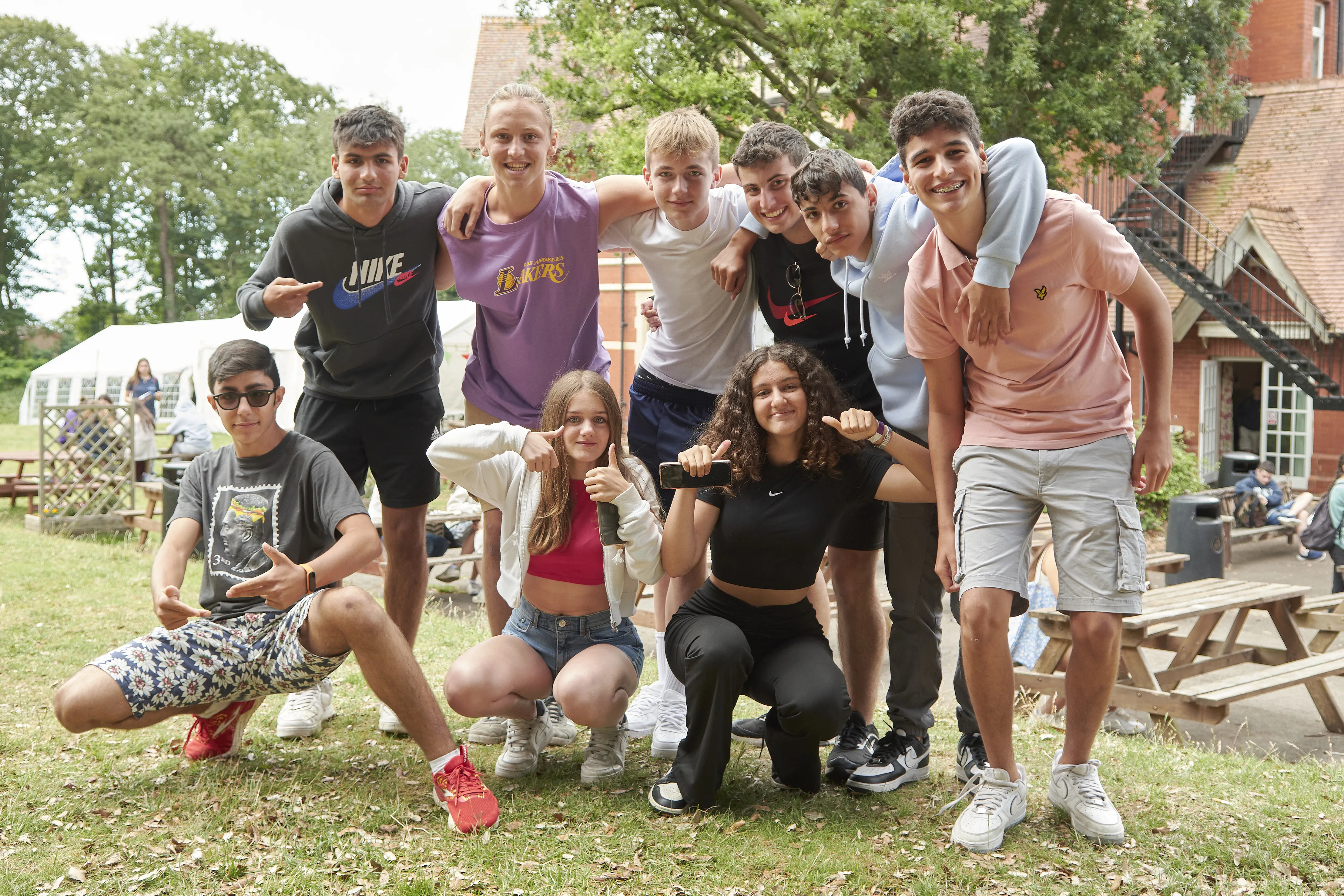 Group of smiling 16-plus students posing together outdoors at Loxdale English Centre in Brighton UK
