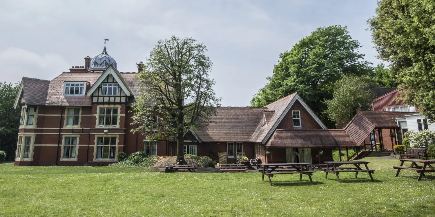 Loxdale English Centre main Victorian building with picnic tables on green lawn in Brighton UK language school campus
