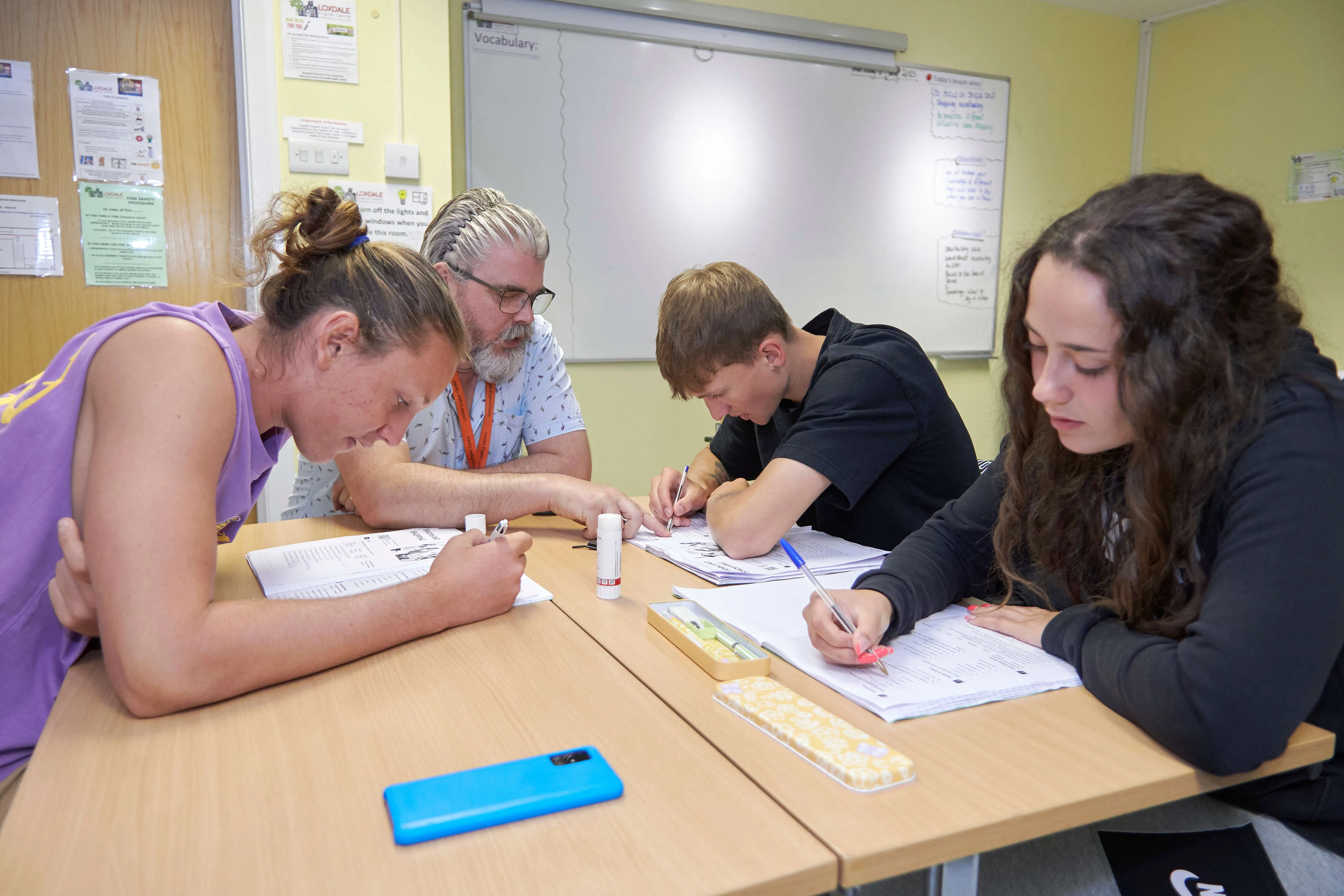 Small group English lesson at Loxdale Brighton with teacher and three students working on worksheets