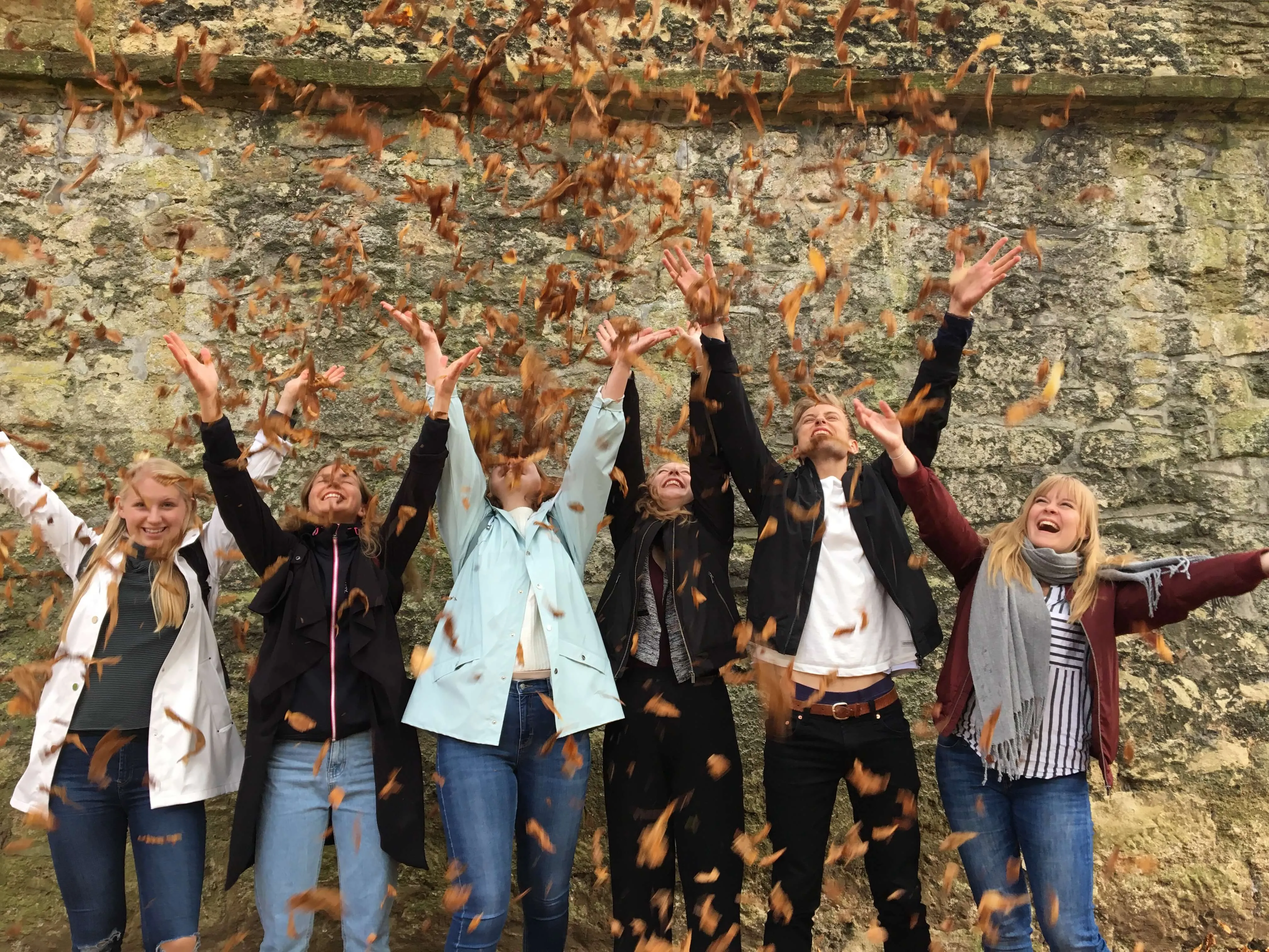 Loxdale English Centre students throwing autumn leaves during social programme activities in Brighton