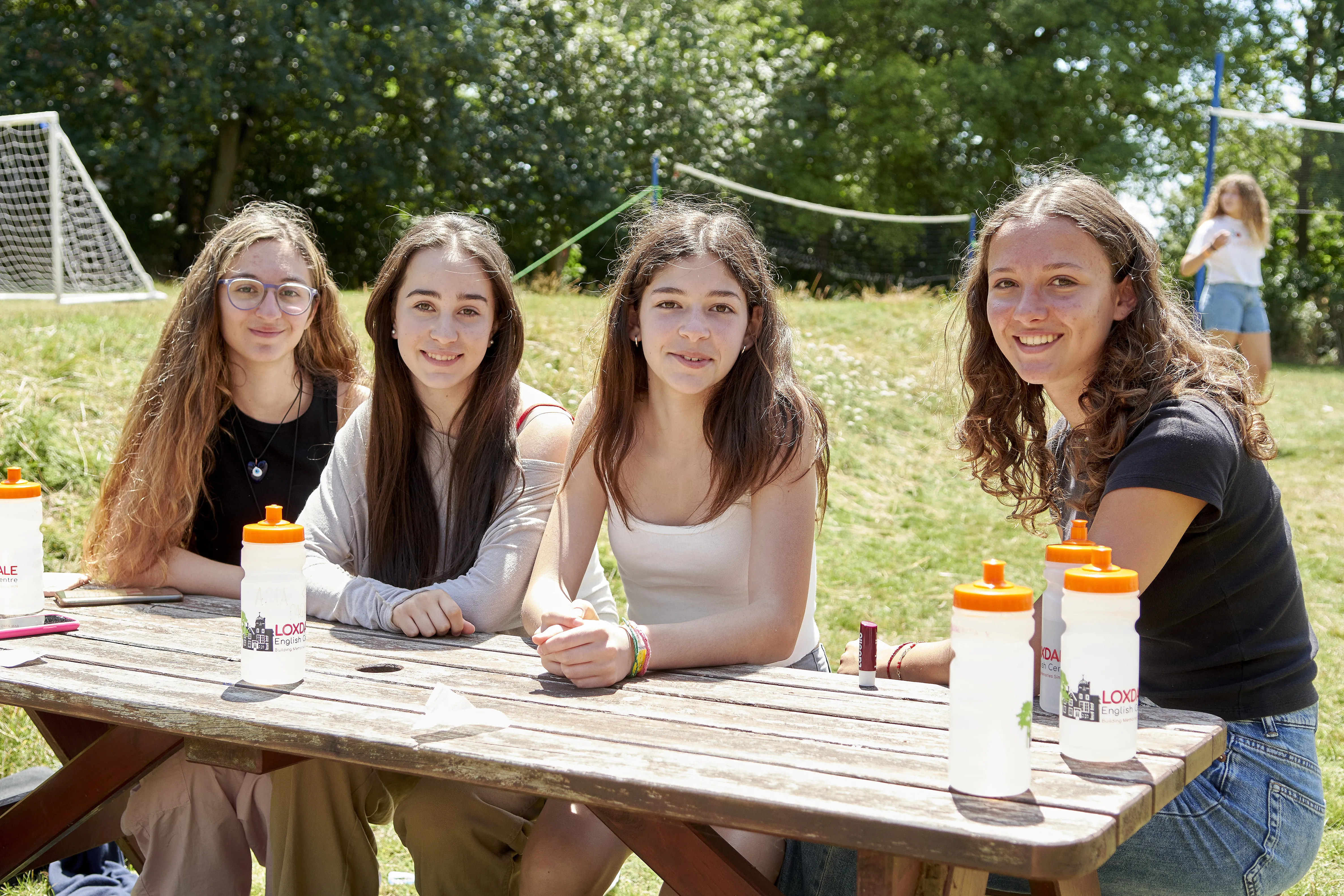 Four female international students enjoying break at picnic table outdoors at Loxdale English Centre Brighton