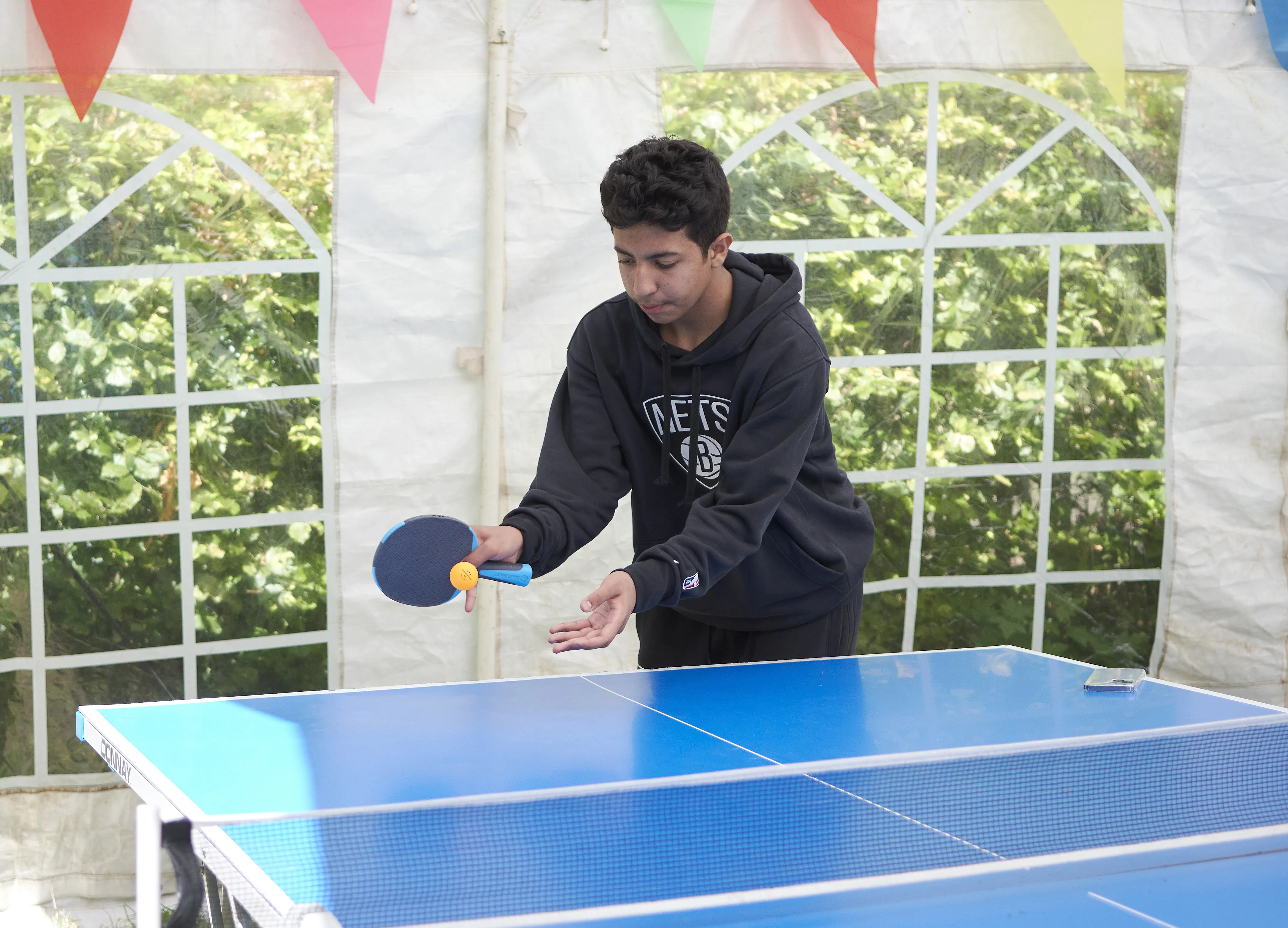 Young student playing table tennis during summer English course activities at Loxdale Brighton