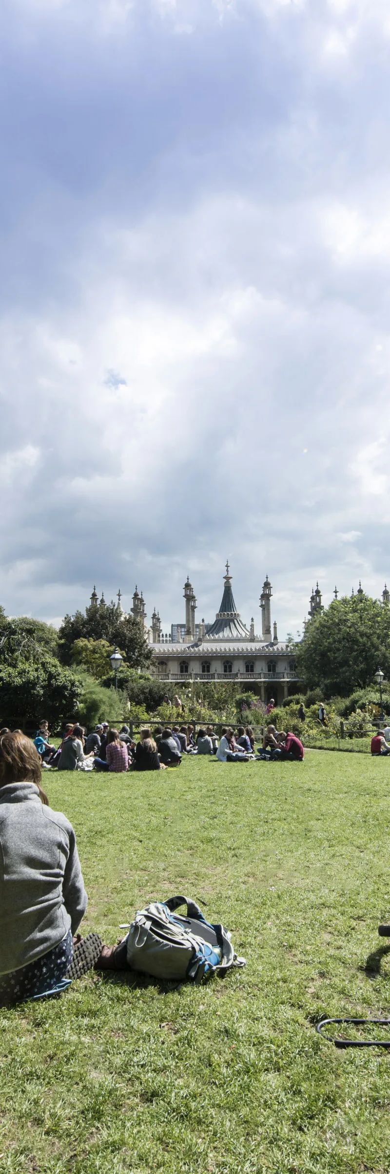 People relaxing on grass in Brighton Pavilion Gardens, popular spot for Loxdale students
