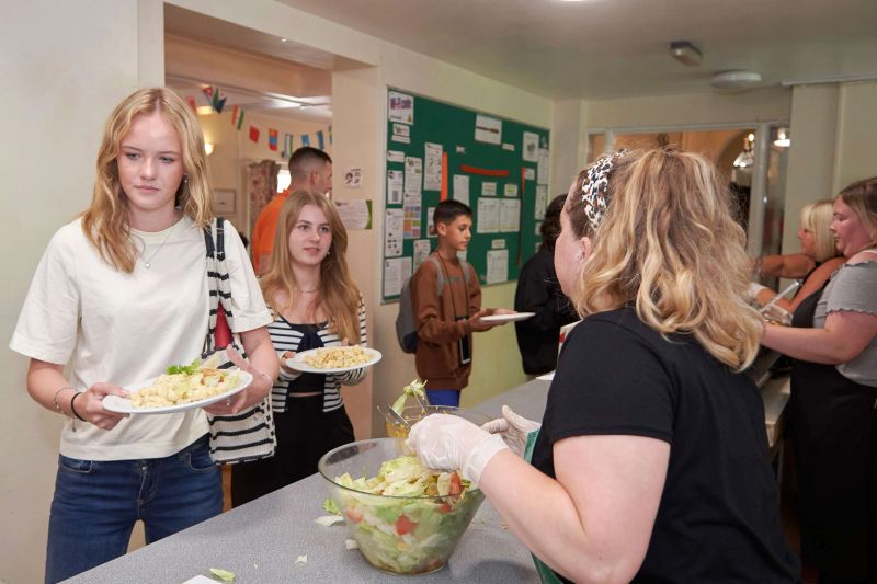 Students being served fresh food in the canteen at Loxdale English school