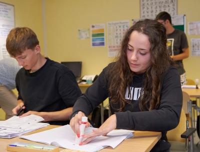 Students working with textbooks and highlighters in small-group English class at Loxdale Brighton