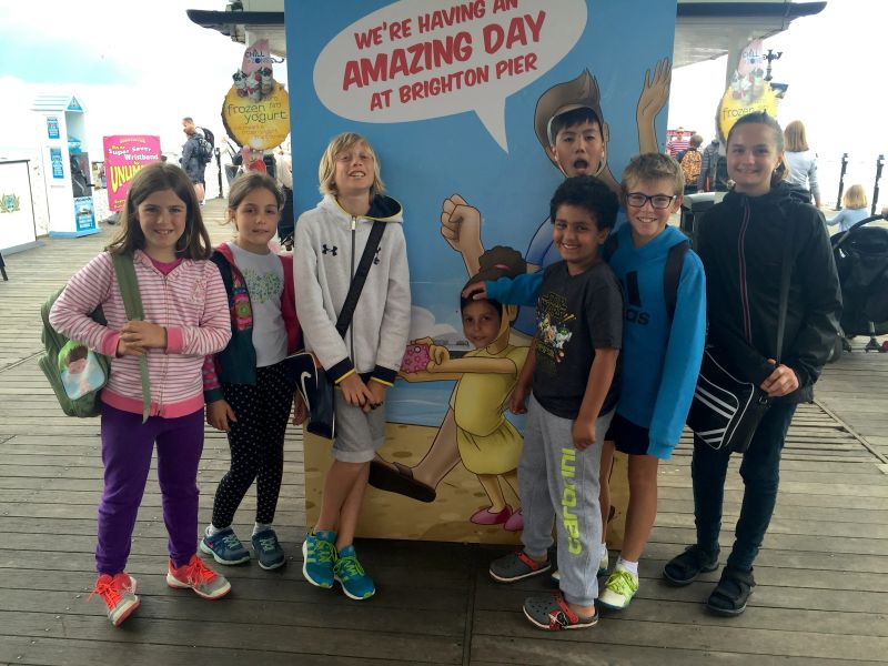 Pre-teen students having fun on Brighton Pier during Loxdale summer course excursion