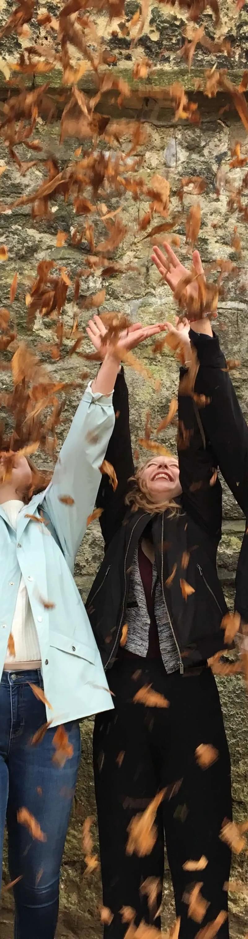 Happy international students throwing autumn leaves in the air at Loxdale English Centre Brighton