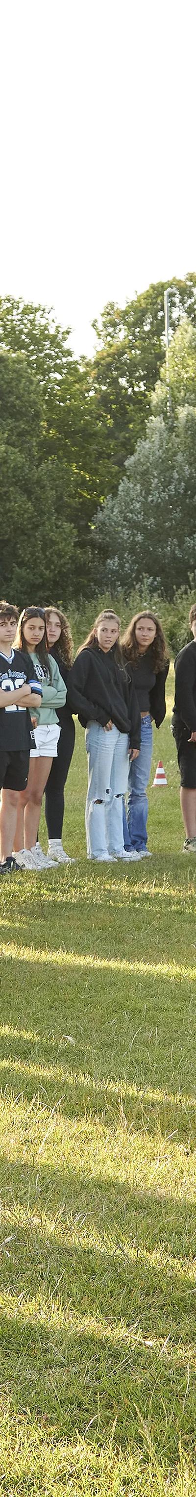 Students gathering on sports field for outdoor activities and games at Loxdale