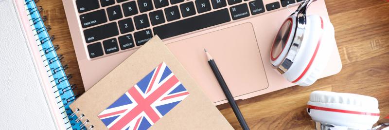 British flag notebook with rose gold laptop and headphones for English learning at Loxdale Brighton