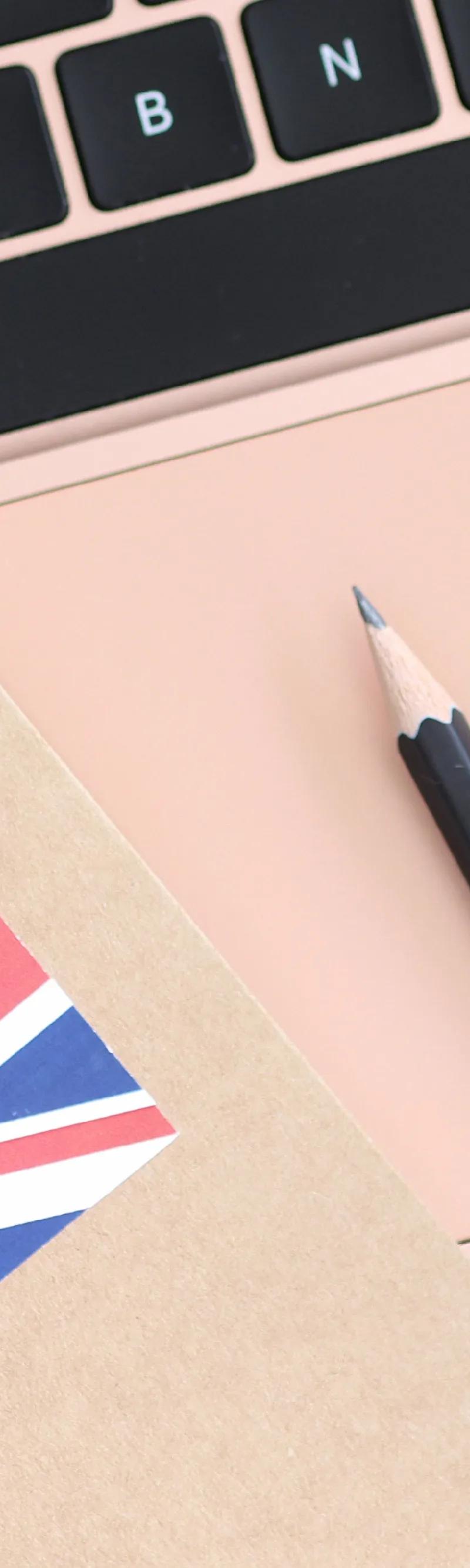 British flag notebook with rose gold laptop and headphones for English learning at Loxdale Brighton