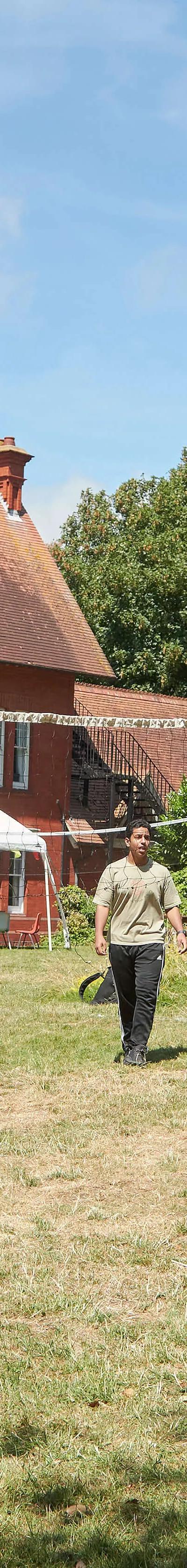 Students playing volleyball on grass field at Loxdale English Centre Brighton