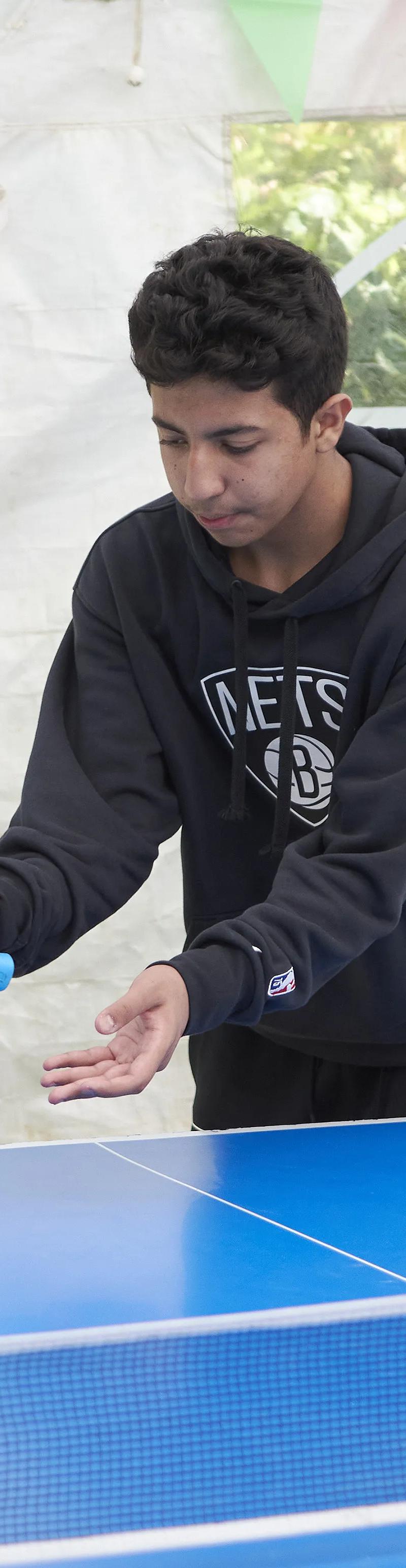 Young student playing table tennis during summer English course activities at Loxdale Brighton